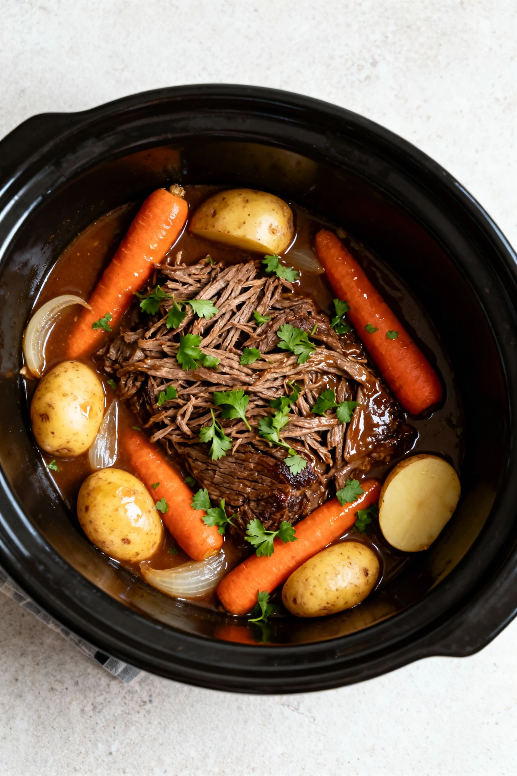 2. Tasty top view: overhead of finished slow-cooker pot roast—shredded beef nestled with tender carrots, halved baby Yuk