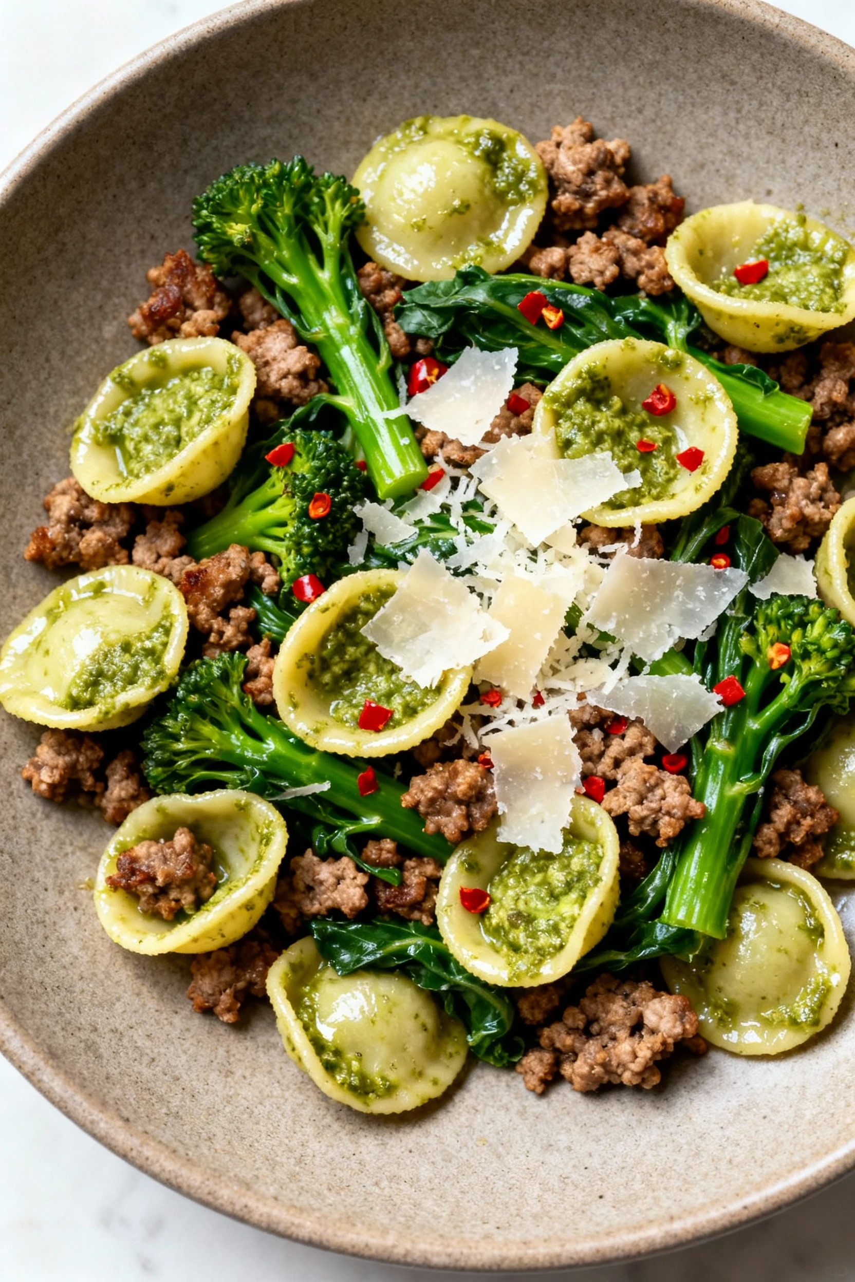 Overhead of Pesto Sausage Orecchiette with Broccoli Rabe: browned sausage crumbles, bright green rabe, glossy orecchiett