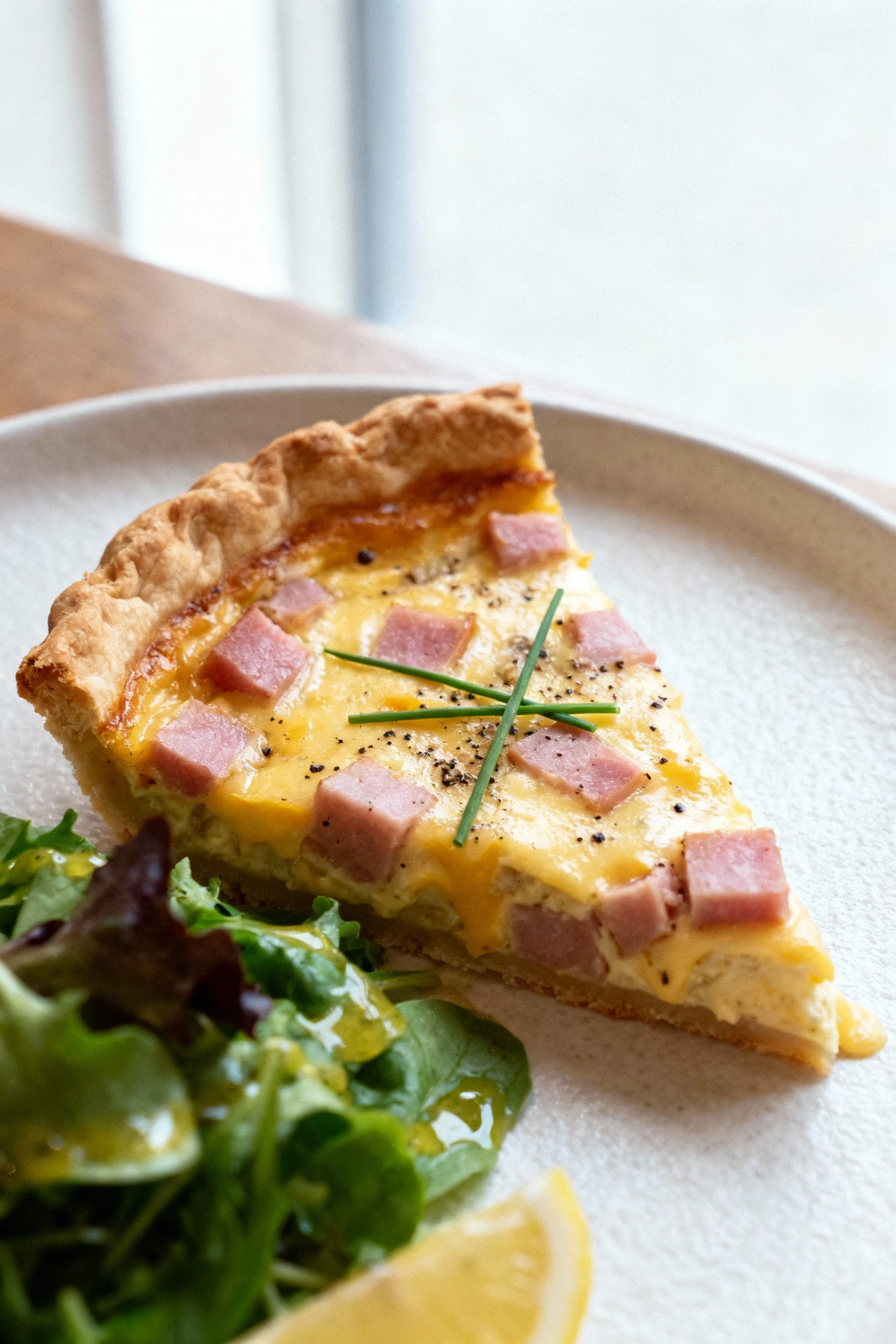 3. Beautifully plated slice of ham and cheese quiche—flaky browned crust, silky custard with pink ham and melted sharp c