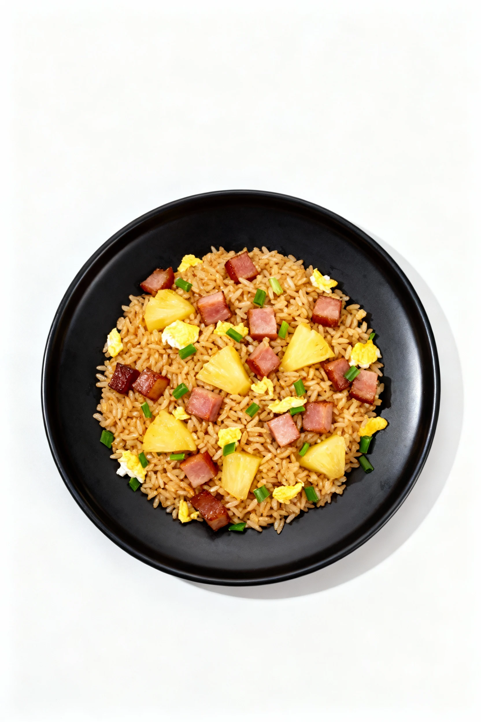Top-down shot of pineapple and ham fried rice: golden-brown grains, caramelized ham cubes, juicy pineapple chunks, egg b