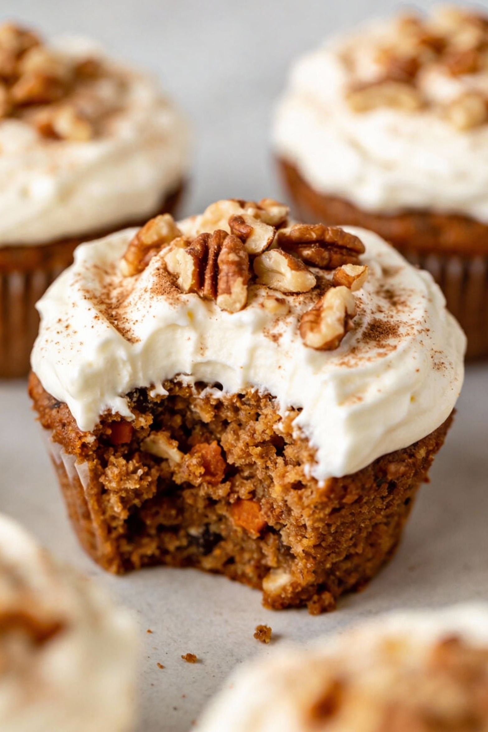 Carrot cake shortcut cupcakes freshly frosted with thick cream cheese frosting, topped with toasted chopped walnuts and 